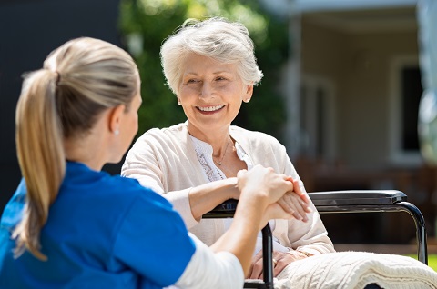 elderly woman smiling with her caregiver