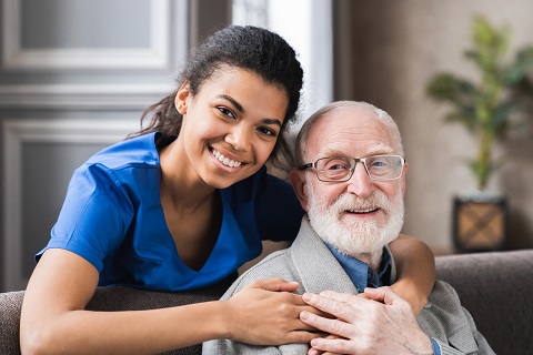 woman caregiver hugging the elderly man