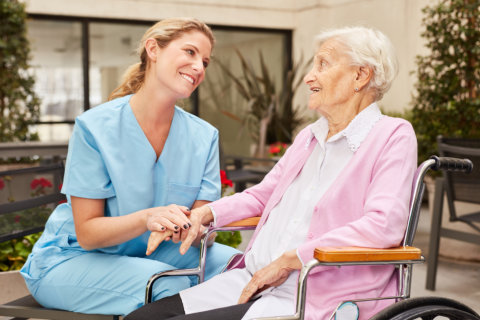 woman caregiver and elderly talking