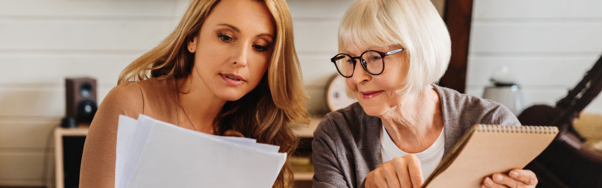 woman and elderly woman looking at the folder