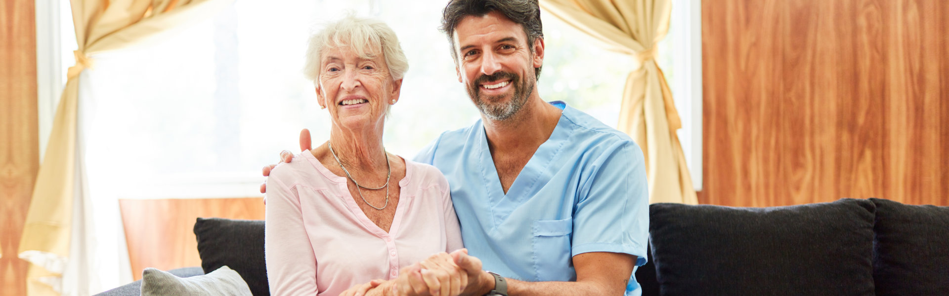 nurse and elderly woman sitting and looking at the camera