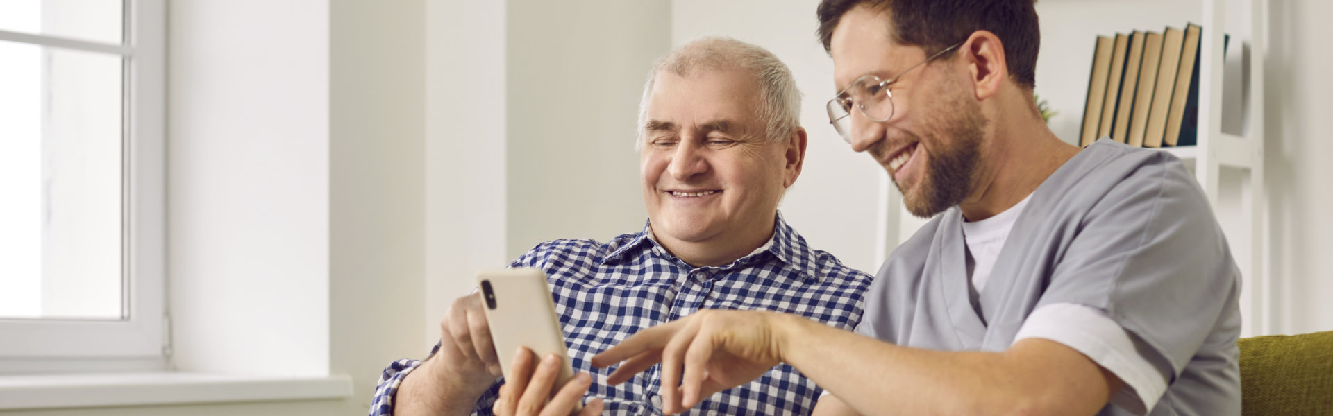 caregiver and elderly reading a website in their phone